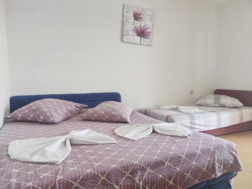 two beds in a room with towels on them at Apartments Kata in Neum
