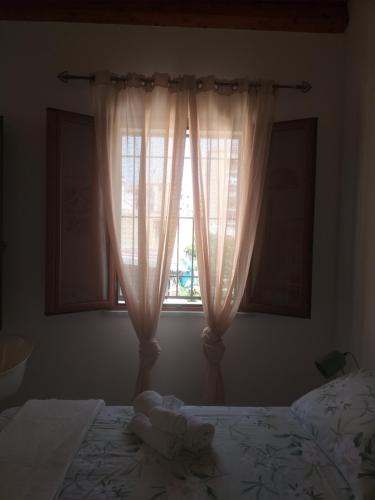 a bedroom with a bed and a window with curtains at Enzo'S Suite in Palermo