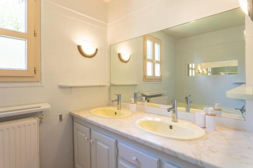 a bathroom with two sinks and a large mirror at Wonderful house in Sarlat center with heated pool & jaccuzi in Sarlat-la-Canéda