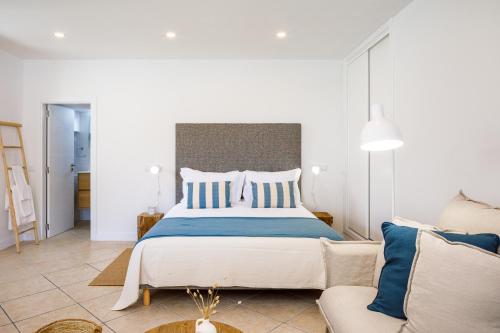 ein Schlafzimmer mit einem großen Bett und einem Sofa in der Unterkunft CASA 4YOU in Carvoeiro