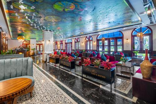 a hotel lobby with couches and a painting on the ceiling at Grand Fleuve Boutique in Ha Long