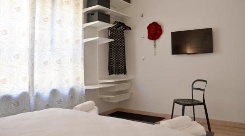 Schlafzimmer mit einem Bett, einem TV und einem Stuhl in der Unterkunft YesHouse in Turin