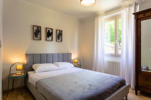 um quarto com uma cama grande e uma janela em Wonderful house in Sarlat center with heated pool & jaccuzi em Sarlat-la-Canéda