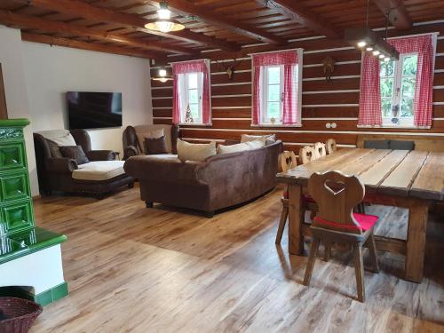 a living room with a couch and a table and chairs at BP Chata Ostružná in Ostružná