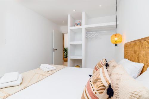 a white bedroom with a bed and a lamp at Soltroia lake Dream house in Troia