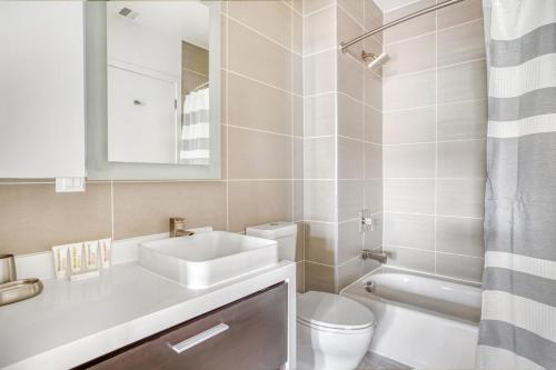 a bathroom with a sink and a toilet and a mirror at Navy Yard 1BR w Gym WD steps from Nats Park WDC-325 in Washington, D.C.