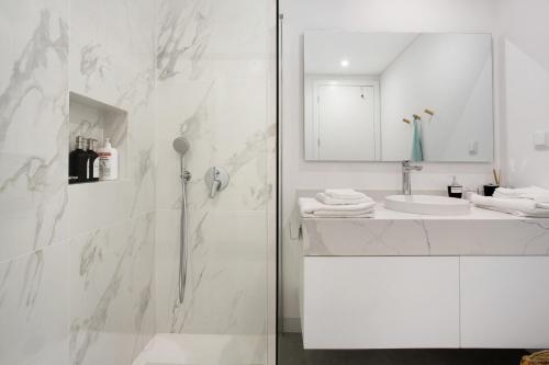 baño blanco con ducha y lavamanos en Casa Castanheta en Câmara de Lobos