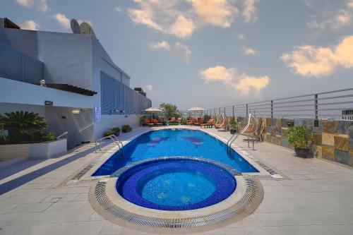 einem großen Pool an der Seite eines Gebäudes in der Unterkunft Icon Delux Hotel Apartments Al Barsha - Formerly Abidos in Dubai