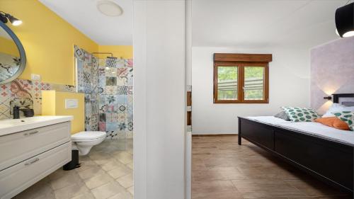 een badkamer met een bed, een toilet en een wastafel bij Villa Tai in Puntera