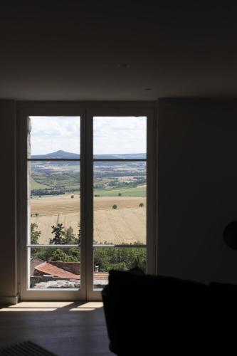 a room with a large window with a view of a field at Hôtel & Restaurant Origines par Adrien Descouls - Teritoria in Issoire