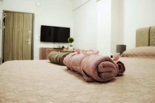 Una toalla rosa está en una cama en Dionysos Apartment in Central Athens en Atenas