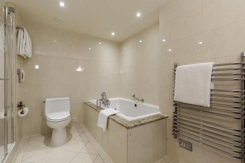 a bathroom with a toilet and a sink and a bath tub at Old Course Hotel St Andrews in St. Andrews