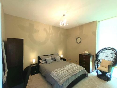 a bedroom with a bed and a chair at Beautiful 2-Bed Apartment near Waterford City in Waterford