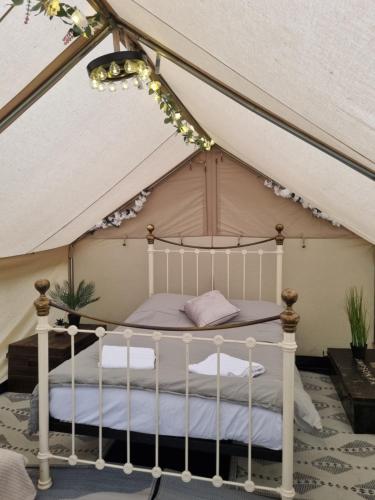 a bedroom with a bed in a tent at Glamping in style, Prospector Tent in Crawley