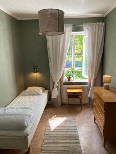 a bedroom with a bed and a window at Elisabets Vandrarhem Hemse in Hemse