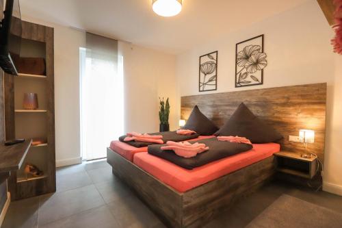 ein Schlafzimmer mit einem großen Bett mit einem hölzernen Kopfteil in der Unterkunft Appartementhaus kleines Glück &MeineCardPLUS in Willingen