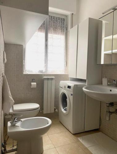 a bathroom with a washing machine and a sink at Le Rose Apartment in Ortona
