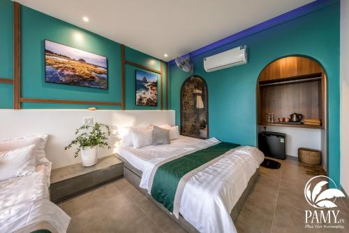 a bedroom with a large bed and blue walls at PAMY Homestay Phú Yên in Phu Yen
