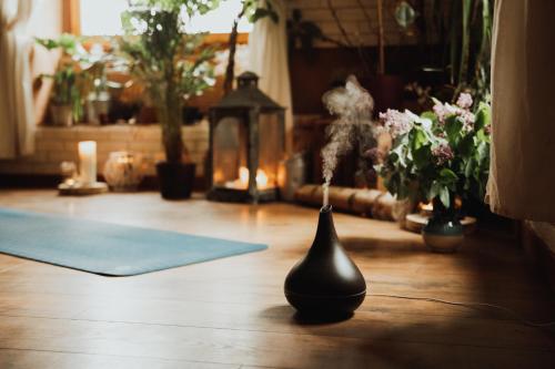 a black vase on the floor in a room with flowers at Jasminowe Wzgorze in Wilkanów