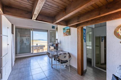 une cuisine avec une table et une vue sur l'océan dans l'établissement La Sandune, à Marseillan