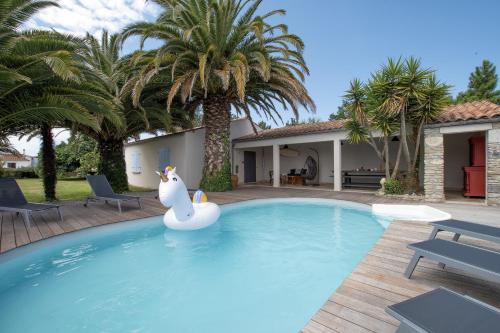 - une piscine avec un pingouin gonflable en face d'une maison dans l'établissement Villa La Jonchère, à Saint-Georges-dʼOléron