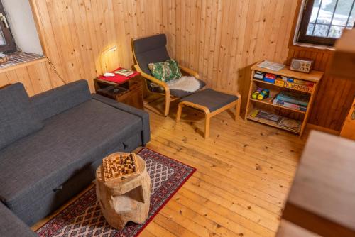 - un salon avec un canapé et une chaise dans l'établissement Chalet Bohinj, à Bohinj