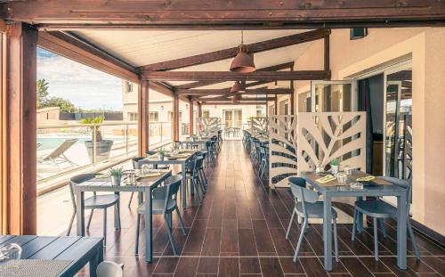 a restaurant with tables and chairs on a patio at Best Western Marseille Aeroport in Vitrolles