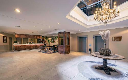 a large living room with a chandelier and a table at Best Western Marseille Aeroport in Vitrolles