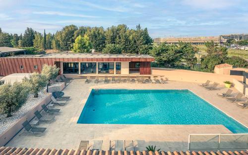 an overhead view of a pool with chairs and a building at Best Western Marseille Aeroport in Vitrolles