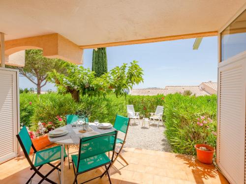 un patio avec une table et des chaises sur un patio dans l'établissement Apartment Les Coteaux de la Nartelle-22 by Interhome, à Sainte-Maxime