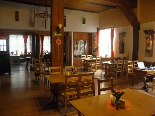 un restaurante vacío con mesas y sillas de madera en Dom Turysty Pod Wieżycą en Sobótka