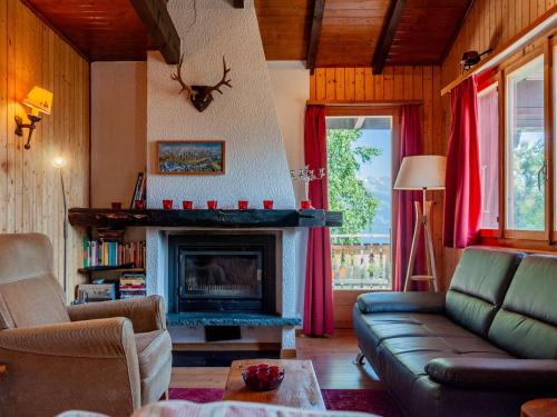 a living room with a couch and a fireplace at Chalet Le Hibou by Interhome in Nendaz