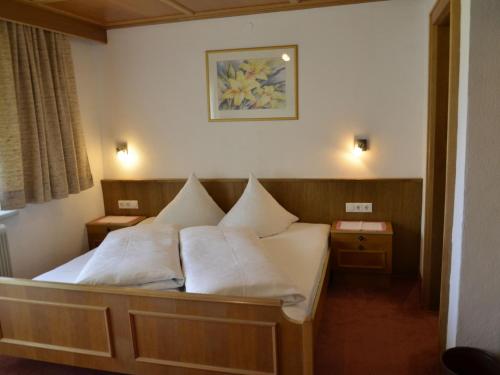 - une chambre avec un lit doté de draps et d'oreillers blancs dans l'établissement Apartment Ferienglück - KPL396 by Interhome, à Kappl