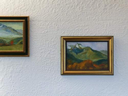 two paintings hanging on a white wall at Apartment Gai Matin A 9 by Interhome in Chesières