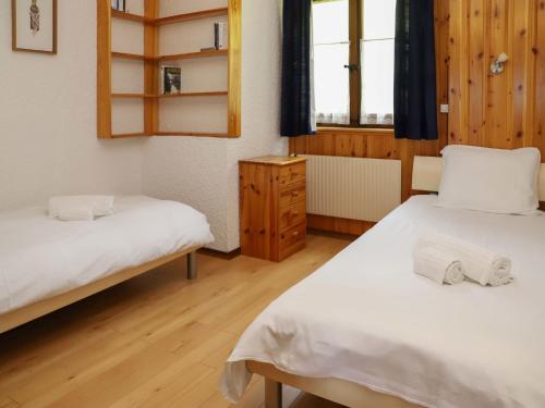 a bedroom with two beds and a mirror and a window at Apartment Gai Matin A 9 by Interhome in Chesières