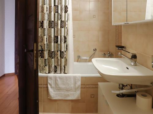 a bathroom with a sink and a shower curtain at Apartment Gai Matin A 9 by Interhome in Chesières