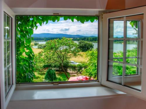 een raam met uitzicht op een rivier en bomen bij Chalet Karasova II - DEH102 by Interhome in Dehtáře