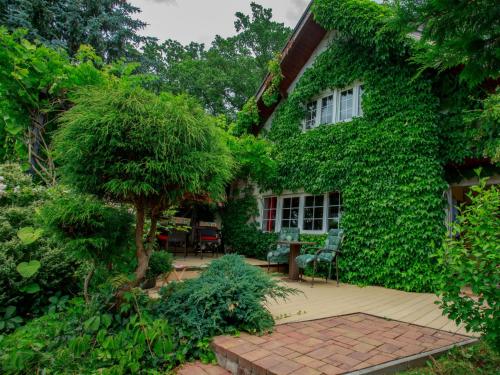 a house covered in green ivy with a patio at Chalet Karasova II by Interhome in Dehtáře