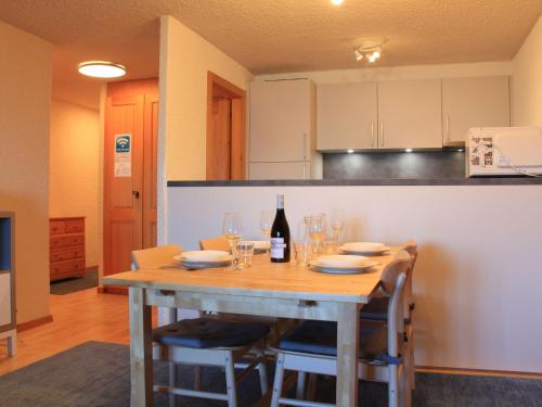 ヴィラール・シュル・オロンにあるApartment Ambassadeur 15 by Interhomeのキッチン(木製テーブル、ワイングラス付)