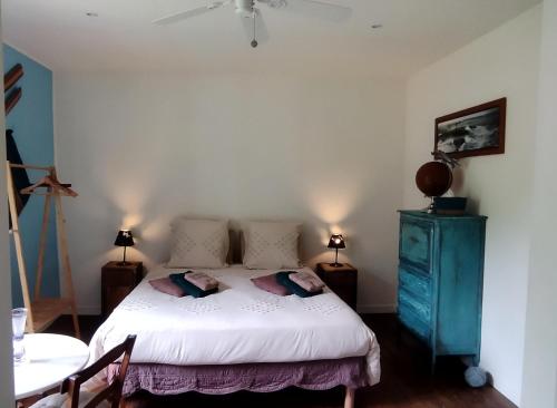 a bedroom with a white bed and a blue cabinet at Au Bois de la Grave in Luzech