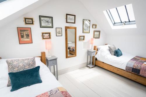 a bedroom with two beds and a mirror on the wall at Hilltop Farm - Middle Barn luxury accommodation in Tansley