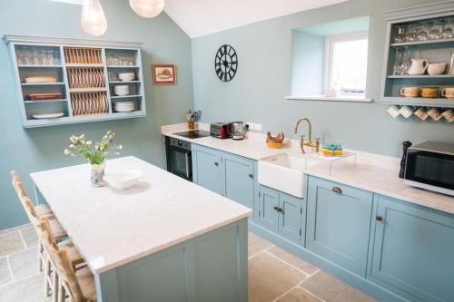 a kitchen with blue cabinets and a white counter top at Hilltop Farm - Middle Barn luxury accommodation in Tansley