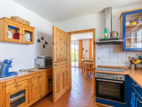 a kitchen with wooden cabinets and a stove top oven at Holiday Home Losentitz-2 by Interhome in Zudar