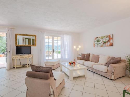 a living room with a couch and a table at Holiday Home Mas des Chênes - GRI120 by Interhome in Grimaud
