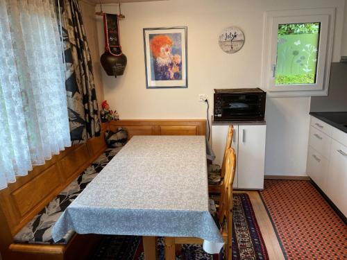 una pequeña cocina con mesa, fregadero y ventana en Chalet Margrith by Interhome, en Oberwilen