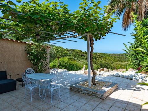 a patio with a table and chairs and a tree at Holiday Home Campestra by Interhome in Coti-Chiavari