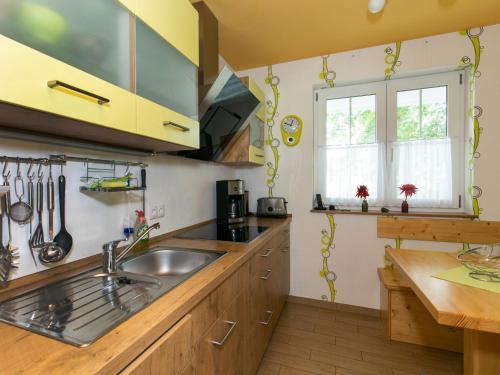 a kitchen with wooden cabinets and a sink at Holiday Home Boddenruhe by Interhome in Ummanz