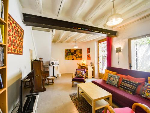 シセ・アン・トゥレーヌにあるHoliday Home Au Soleil Joyeux - CTU201 by Interhomeの紫色のソファとテーブル付きのリビングルーム