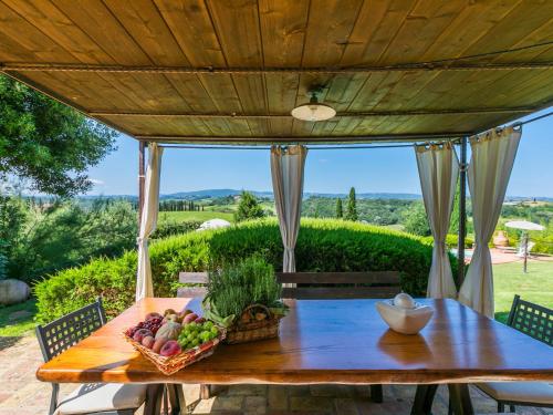 uma mesa de madeira com uma cesta de frutas num pátio em Holiday Home Casa Mori by Interhome em Vico dʼElsa