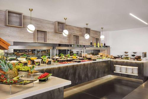 ein Restaurant mit einem Buffet mit Obst und Gemüse in der Unterkunft Ramada Plaza By Wyndham Batman in Batman